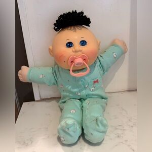 2008 Play Along Babyland Baby CPK boy. Dark brown tuft of hair, blue eyes, paci